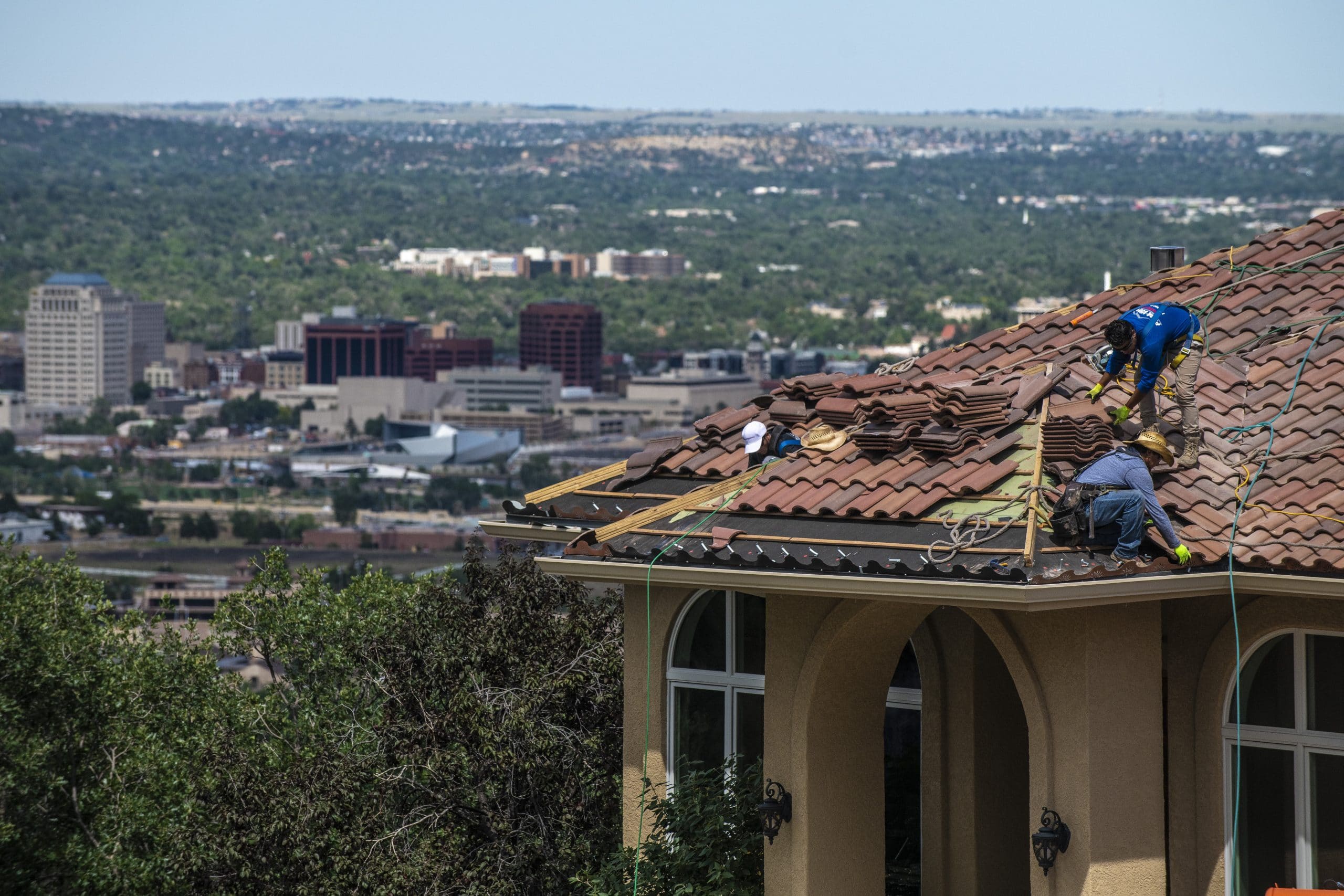 three men replacing a roof in colorado